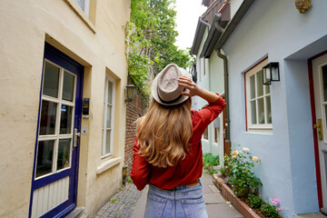 Beautiful traveler woman walking in Schnoor neighborhood, Bremen, Germany