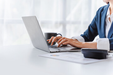 Young Asian business woman working with laptop computer at workspace, modern office.