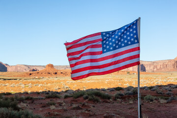 American National Flag in Desert Rocky Mountain Landscape. Sunny Blue Sky Day. Oljato-Monument Valley, Utah, United States. Nature Background