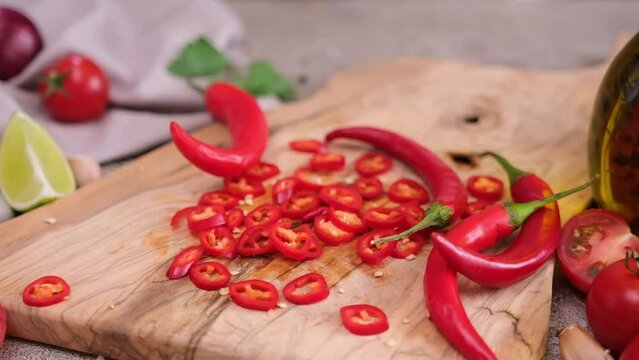 sliced chopped chili pepper on wooden cutting board at domestic kitchen