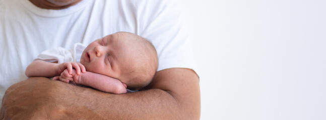 Father holding his newborn on hands. Kid sleeping soundly and peacefully. Strong manly hand hold...