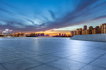 Empty floor and modern city skyline with building scenery at sunset in Suzhou, China.