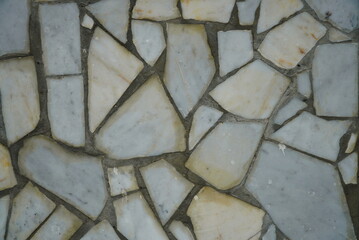 Top view of the old floor, made of various sized pieces of white and gray marble.