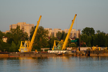 Floating crane in the river port on a summer day. The concept of export and import of goods
