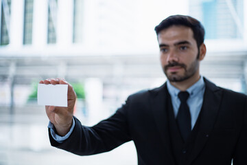 Handsome young businessman in a successful suit provide his connection information for those who are interested in wanting him to be a consultant in business.