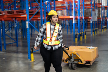 Overweight fat woman in large warehouse  with high level of warehouse steel blue racking pulling hand pallet truck  looking around to find correct storage scan location
