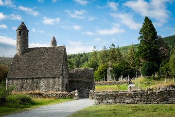 Fototapeta na wymiar Saint Kevin's church in the Glendalough monastery in Co Wicklow Ireland set in a valley on a sunny day showing perfectly green natural countryside. Irish tourist attraction