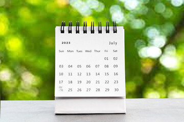 July 2023 desk calendar for planners and reminders on a black table on the natural background.