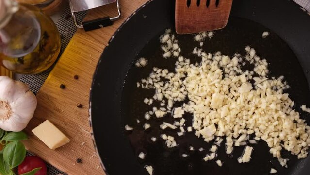 making pasta carbonara - chopped minced garlic into frying pan
