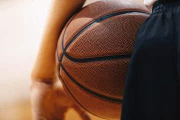 Fototapeten Basketball player holding game ball. Basketball training session. Closeup image of basketball © matimix