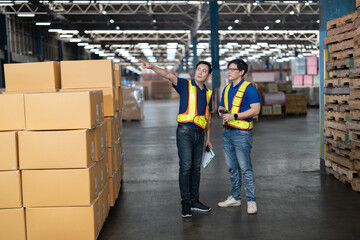 2 man manager and staff  working in the large storage warehouse meet agreement concluded on how...