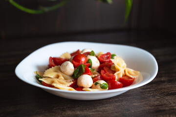 Pasta salad with tomato, mozzarella and basil. Quick and cold summer dish, ideal for a vegetarian diet. Convenient food to take to the office.