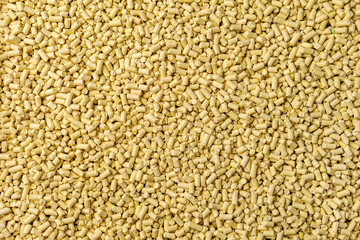 Hygienic natural clumping cat litter. Texture of vegetable fiber granules. Yellow corn tofu close...