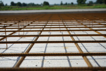 Reinforced concrete road construction and the process of placing the steel grating to prevent cracks (blurred image)