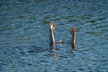 a man's hand above the surface of the water in the river, saving drowning