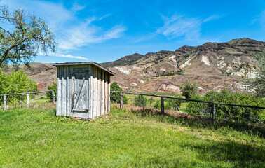 An abandoned outhouse on a ranch among the hills in central Oregon, USA