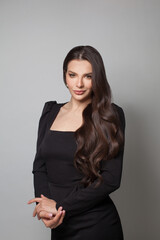 Elegant woman in black dress posing on white background