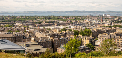 Fototapeta na wymiar Edinburgh, Scotland, UK – June 20 2022. A view over the Edinburgh skyline towards the Firth of the Forth captured from Calton Hill