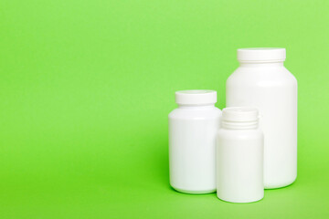 supplement pills with medicine bottle health care and medical top view. Vitamin tablets. Top view mockup bottle for pills and vitamins with green leaves, natural organic bio supplement, copy space