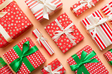 Fototapeta premium A lot of Christmas gift boxes in colored paper decorated on table, Top view close up. Many present New Year gift