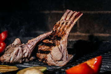 Meat lamb on the grill. Lamb ribs on board with grilled vegetables. Restaurant menu, Culinary,...