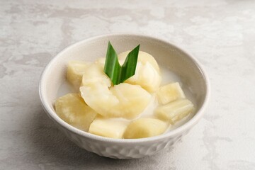 Singkong thailand, sweet cassava, made of boiled cassava, sugar and coconut milk. Served in bowl and pandan leaf.
