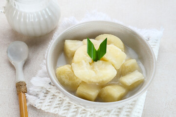 Singkong thailand, sweet cassava, made of boiled cassava, sugar and coconut milk. Served in bowl and pandan leaf.
