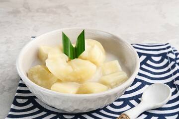 Singkong thailand, sweet cassava, made of boiled cassava, sugar and coconut milk. Served in bowl and pandan leaf.
