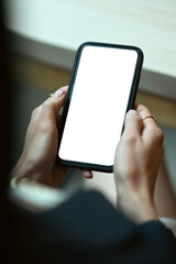 Close up view of woman hands holding mobile phone. White display for your advertise text