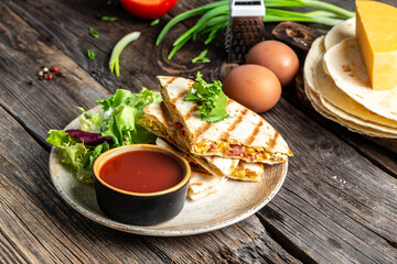 Traditional Mexican tortillas with quesadilla with scramble eggs, vegetables, ham and cheese. Mexican cuisine, Mexico and Latin America traditional restaurant menu dish