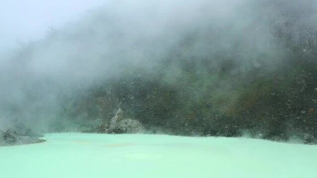 camera panning right along extreme sulfur lake at Kawah Putih in Bandung Indonesia