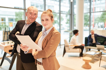 Erfolgreicher Berater und junge Kollegin als Trainee im Büro