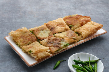 Martabak, Martabak Telor or Martabak Telur. Savory pan-fried pastry stuffed with egg, meat and spices. Martabak Telur is one of Indonesia street food. Served on white plate.
