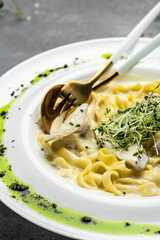 Fettuccine alfredo in a creamy sauce with chicken, parmesan on white plate. Pasta alfredo with chicken. Italian cuisine. vertical image. top view. place for text