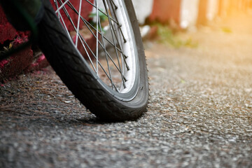 Naklejka premium Bike flat tires which parked on red-white line beside the road in the public park, soft and selective focus on tire.
