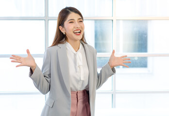 Millennial Asian young cheerful professional successful businesswoman in formal suit standing...