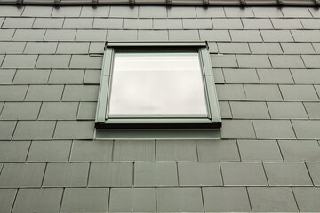 Modern skylights on a green roof. Construction of a roof with roof windows in the attic. Close-up view of dormer roof window.