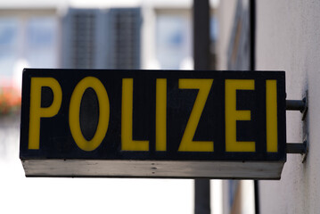 Close-up of black and yellow police (German Polizei) sign at police station at City of Altdorf, Canton Uri, on a sunny summer day. Photo taken June 25th, 2022, Altdorf, Switzerland.