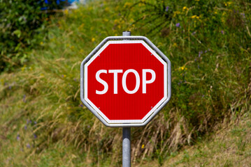 Close-up of red and whit stop road sign at village of Airolo, Canton Ticino, on a sunny summer day. Photo taken June 25th, 2022, Airolo, Switzerland.