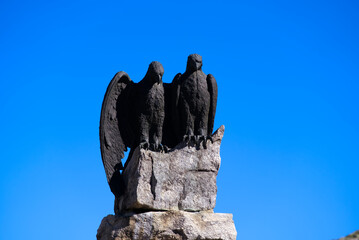 Memorial of crashed and deadly wounded pilot of the Swiss Air Force Adrien Guex at year 1927 with stone pedestal and metal eagle sculptures. Photo taken June 25th, 2022, Gotthard Pass, Switzerland.