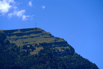 Top of mount Rigi with communications tower and paraglider on a sunny summer day. Photo taken June 25th, 2022, Airolo, Switzerland.