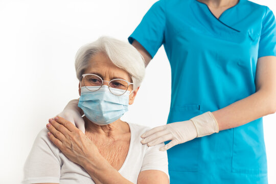elderly woman wearing a mask is been taken care by a young female nurse - studio isolated high quality photo shoot. High quality photo