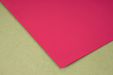 Plain pink red paper sheet lying on brown yellow textured Background like an open book from top angle	