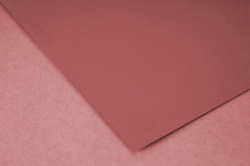 Plain red paper sheet lying on brown textured Background like an open book from top angle	