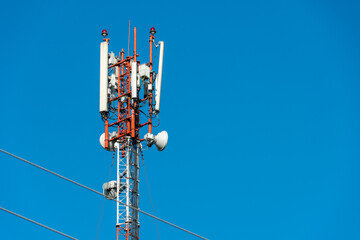 New GSM antennas on a high tower against a blue sky for transmitting a 5g signal are dangerous to health. Radiation pollution of the environment through cell towers. The threat of extinction