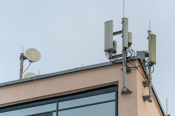 Fototapeta na wymiar New GSM antennas on the roof of a building for transmitting a 5g signal are dangerous to health. Radiation pollution of the environment through cell towers. The threat of extinction of the population