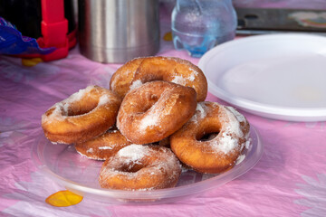 Homemade carnival doughnuts in a household in Bavaria, sprinkled with icing sugar - delicious homemade carnival doughnuts with coffee and cake in the afternoon