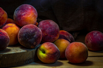 Group of fresh peaches on wood TABLE black background DARK MOOD,  ripe juicy organic  sweet fruit, vegan food, (Prunus persica) Close-Up, Harvest for food