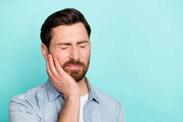 Portrait of frustrated guy touch hand cheek have severe tooth ache isolated on cyan color background