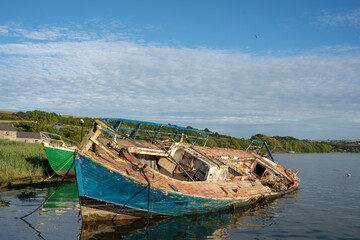 old derelict fishing boat  being broken down  in  breakers yard  wales UK